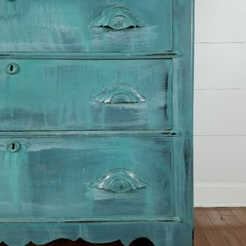 Glimpses of dark wood finish under the drippy paint